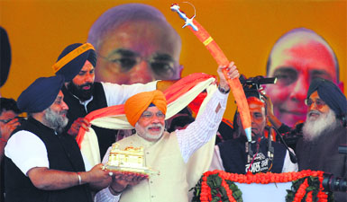 BJP's PM candidate Narendra Modi shows a sword during Fateh Rally in Jagraon near Ludhiana.