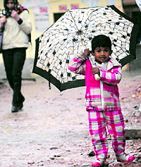 A boy tries to protect himself from showers in Amritsar on Tuesday