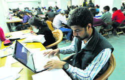 Students of Panjab University study at AC Joshi Library on Tuesday; and (right) fake ID cards. Tribune Photos: Pradeep Tewari