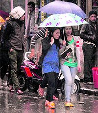 Girls during a heavy downpour in Dehradun on Tuesday