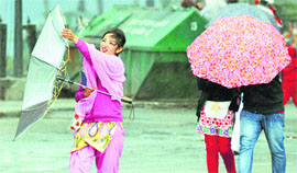 A girl battles with an umbrella during strong winds and rainfall in Shimla on Tuesday.