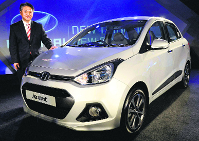 Hyundai Motor India's senior executive director CH Han poses with the new Xcent car at its launch in New Delhi on Wednesday. The car, priced between Rs 4.66 lakh and Rs 7.38 lakh, will be available in two engine options of 1.2 litre petrol and 1.1 litre diesel.