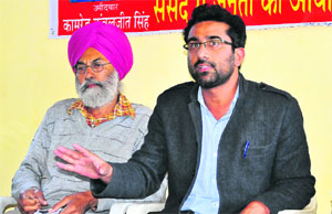 Communist Party candidate Kanwaljeet Singh (right) addresses mediapersons in Chandigarh. 