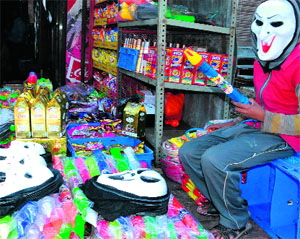 A shopkeeper wearing a mask sells Chinese Holi products in Haridwar on Wednesday.