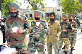 Army personnel outside a polling booth with their voter slips in the Jalandhar cantonment