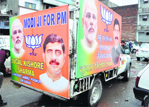 A vehicle displaying pictures of Narendra Modi and Jugal Kishore.
