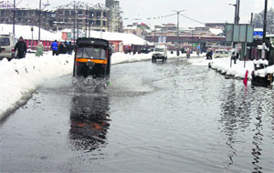 Vehicles pass through a waterlogged road at Jehangir Chowk in Srinagar.