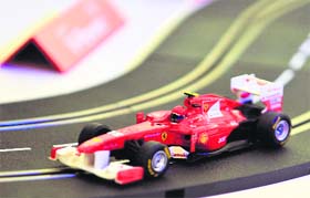 A toy Formula One race car pedal-powered by Ferrari driver Kimi Raikkonen races around the track during a promotional event ahead of the Australian Grand Prix in Melbourne on Wednesday