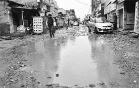 Rainwater accumulates on a road at Balongi village near Mohali.