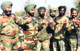 Army personnel show ink mark on their fingers after casting their votes