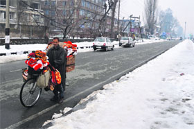 A Kashmiri sells woollen clothes on the banks of the Dal Lake in Srinagar on Thursday. The temperature witnessed a drop after the Kashmir valley received heavy snowfall on Tuesday.