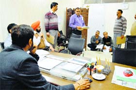RTI activists (sitting on the floor) block the room of an MC official at Zone A office in Ludhiana on Thursday