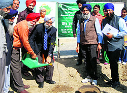 Members of the EcoSikh, an NGO, plant a sapling at Khalsa College in Amritsar on Friday