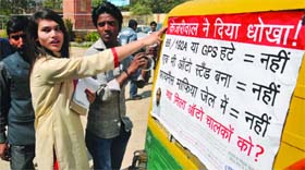 A group of autorickshaw drivers and activists put a poster on an autorickshaw in New Delhi on Friday