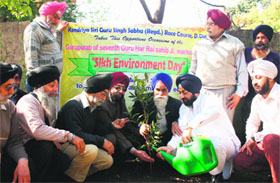 Members of the Kendriya Shri Guru Singh Sabha plant a sapling to celebrate Sikh Environment Day in Dehradun on Friday.