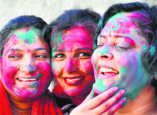 Women apply colours on each others faces to celebrate Holi in Jammu.