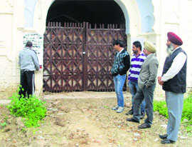 A Revenue Department employee pasting a notice on the building.