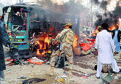 Pakistani soldiers and others react at the site of a bomb explosion in Quetta on Friday