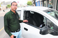 Sachin Baghla shows the window pane of his car which was broken by thieves on Saturday. Tribune photo