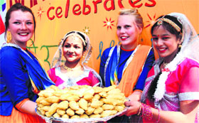 Children from Nanhi Duniya present gujiyas to foreign visitors in Dehradun on Saturday.