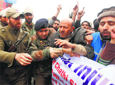 The police detain Awami Itehad Party president and MLA, Langate, Abdul Rashid Sheikh during a protest march in Srinagar, on Saturday.