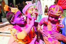 A tourist plays Holi outside the Durgiana temple in Amritsar on Sunday.