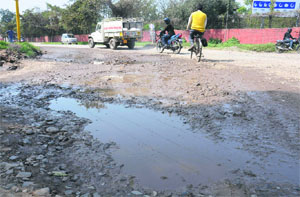 A potholed road in Industrial Area Phase II