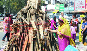 Women perform pooja near Holika on the occasion of Holi festival at Bengali Market in New Delhi on Sunday.