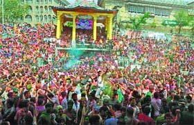 People gather at the Seri Bazar to enjoy the festival of Holi in Mandi on Sunday