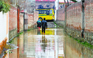 A man wades through a waterlogged road in the Nowgam area of Srinagar on Sunday.