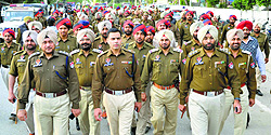 Police hold a flag march at Sarabha Nagar; and (below) a car damaged during a clash between the supporters of Manpreet Singh Ayali and Simarjit Singh Bains
