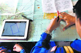 A Malaysian pilot studies the map on board a Japanese Coast Guard Gulfstream V Jet aircraft during the search for the missing Malaysia Airlines MH370 plane over the waters of the South China Sea.