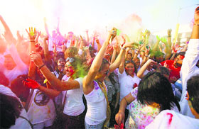 People throw colours as they dance to celebrate the Holi in suburban Pasay, south of Manila, on Sunday.