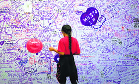 A girl reads messages of support and hope for passengers of the missing Malaysia Airlines MH370, at a shopping mall in Kuala Lumpur.