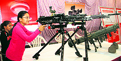 A visitor having a close look at a medium machine gun at the Ordnance Factory Day exhibition in Dehradun