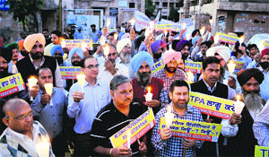 PSPCL engineers take out a candle light march in support of their demands in Amritsar on Wednesday.
