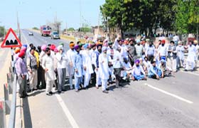 Members of the Punjab State Agricultural Society Employees Union block the Bathinda-Badal road