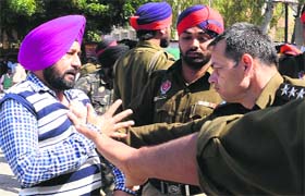Policemen round up an activist; members shout slogans while being taken away by the police in Bathinda on Wednesday