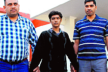 Aman (centre), one of the accused, in police custody