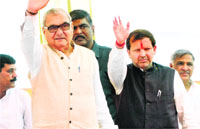 Chief Minister Bhupinder Singh Hooda and Congress candidate from Karnal Arvind Sharma wave to supporters after the latter filed his papers from Karnal on Wednesday. Tribune Photo: Ravi Kumar