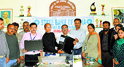 Officials of the State Bank of India hand over a computer to the authorities of Government Higher Secondary School, Smailpur, in Samba district