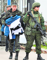 Ukrainian officers leave as Russian soldiers stand guard at the Ukrainian navy headquarters in the Crimean city of Sevastopol on Wednesday. 