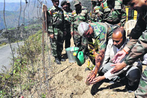 Officials plant a sapling at Jaunsar Bhabhar in Dehradun district on Thursday.