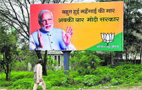 A man looks at the hoarding of BJP prime ministerial candidate Narendra Modi installed on the Jammu-Akhnoor highway.