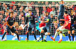 Manchester Uniteds Robin van Persie shoots to score his third goal during their Champions League round of 16 second leg match against Olympiakos in Manchester on Wednesday. AFP