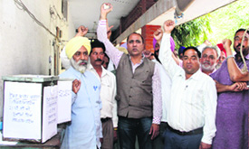 All Punjab Truck Operators Union members hold a protest outside the office of Food and Civil Supplies against the tendering process in Jalandhar on Friday.
