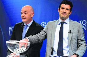 UEFA General Secretary Gianni Infantino and ambassador for the final in Lisbon, Luis Figo, take part in the draw for the quarterfinals of the Champions league in Nyon on Friday