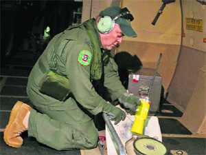 A flight officer aboard an aircraft prepares to launch a sonar buoy to trace the missing Malaysian jetliner on Saturday. 