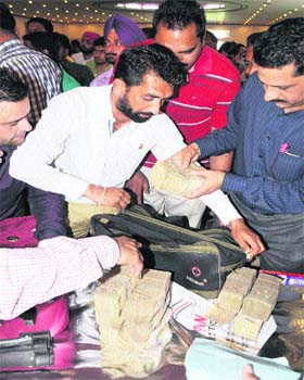 Liquor vendors deposit money with officials of the Excise Department after the auction in Ludhiana on Saturday
