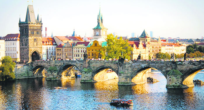 Tourists throng Charles Bridge on Vltava River to get a stunning view of sunset. thinkstock